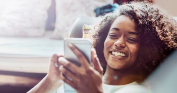 Instagram-Accounts rund um Liebe, Dating, Beziehungen und Sexualität Frau schaut sich glücklich etwas auf ihrem Handy an