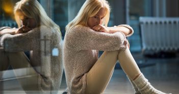 Verordnetes Hikikomori – Mutieren Singles durch die Coronakrise zu Einsiedlern? Frau sitzt nachdenklich auf dem Boden und wirkt unglücklich