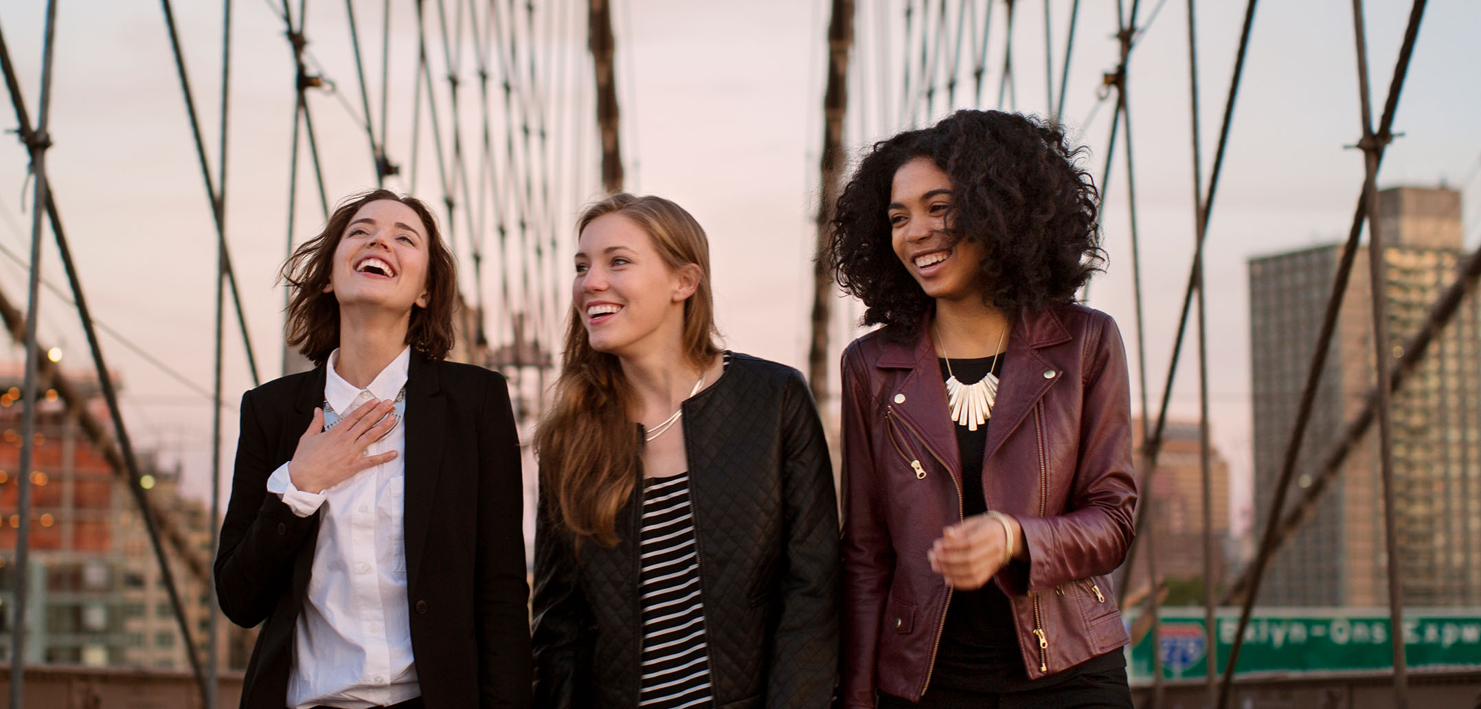 Drei Frauen gehen über die Brooklyn Bridge in New York