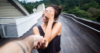 Kann Liebe blind sein? Ein Interview mit Diplom-Psychologin Lisa Fischbach Frau hält sich lächelnd die Augen zu, während sie die Hand eines Mannes hält