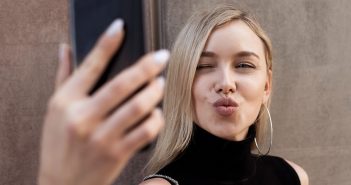 Macht Online Dating einsam? Eine Frau macht ein Selfie mit Kussmund
