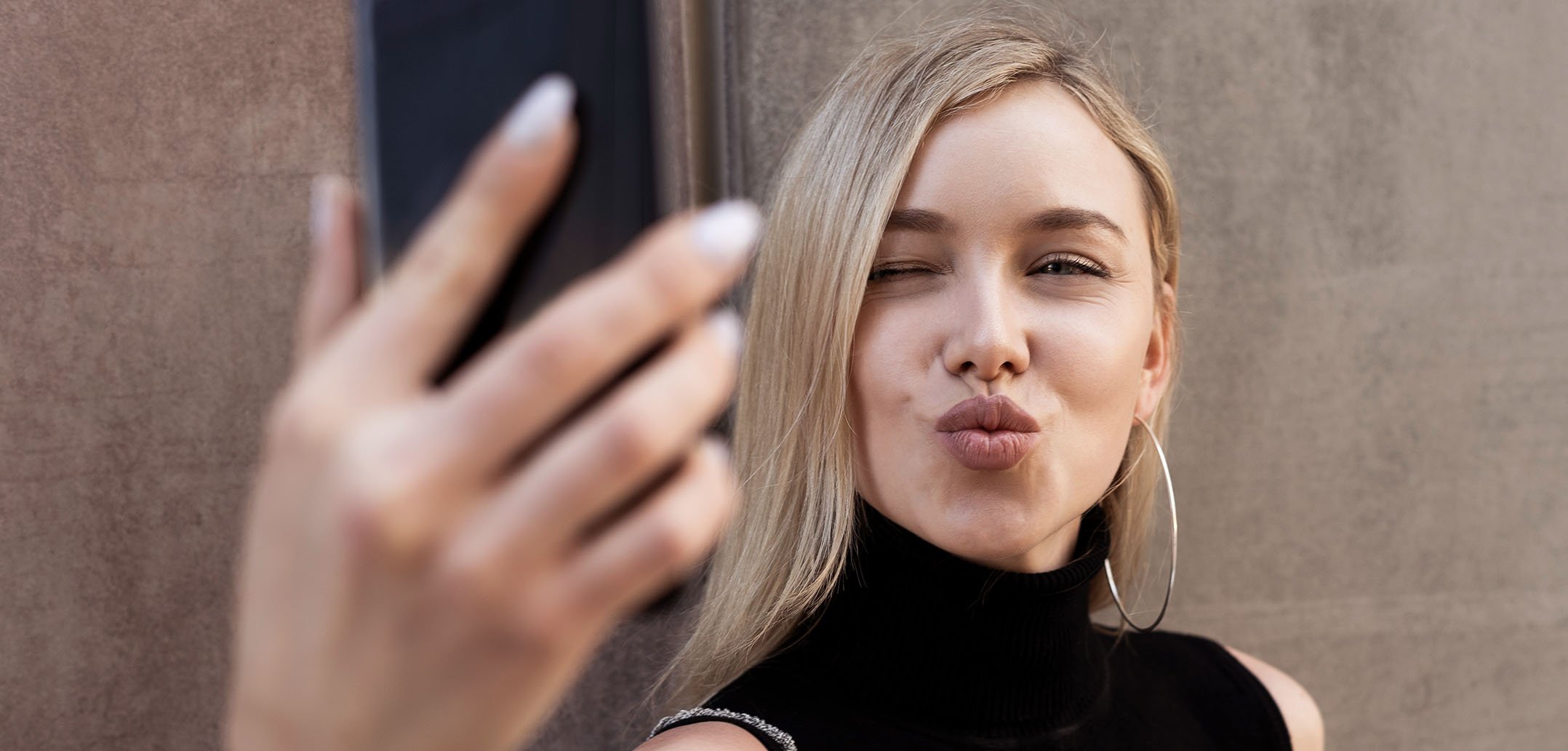 Eine Frau macht ein Selfie mit Kussmund