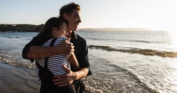 Woran erkennst du, dass deine Beziehung lange halten wird? Pärchen schaut glücklich ins Meer hinaus