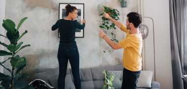 Paar hängt gemeinsam ein Bild auf