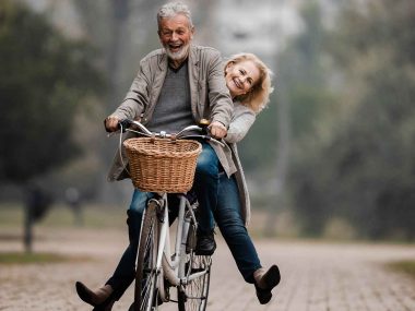 Jung gebliebenes Pärchen zusammen auf einem Fahrrad